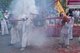 Thailand: Shop owners wave bamboo poles with strings of exploding firecrackers over the heads of shrine bearers, Phuket Vegetarian Festival